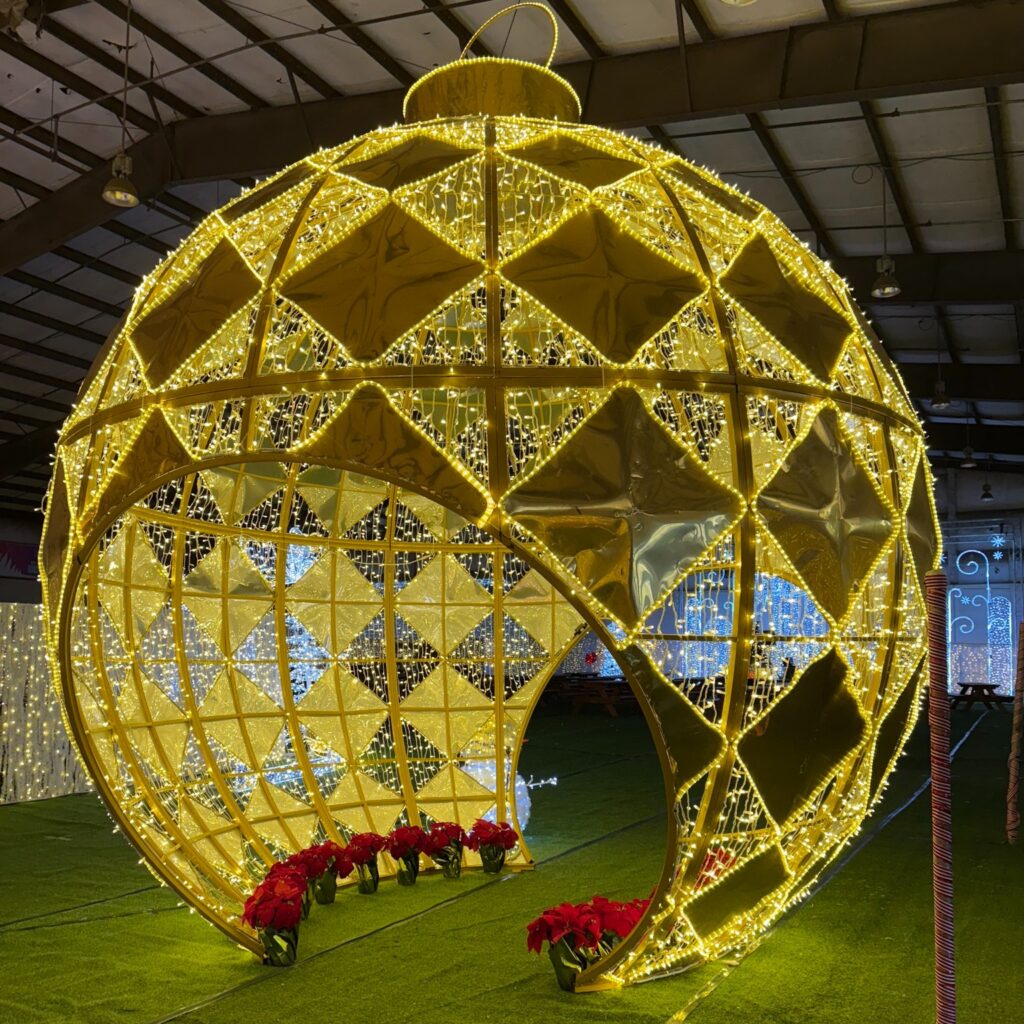 A massive gold Christmas ornament that you can walk through created from Christmas lights.