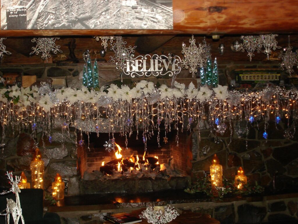 A fireplace decked out with Christmas lights and other Christmas décor. It's very pretty.