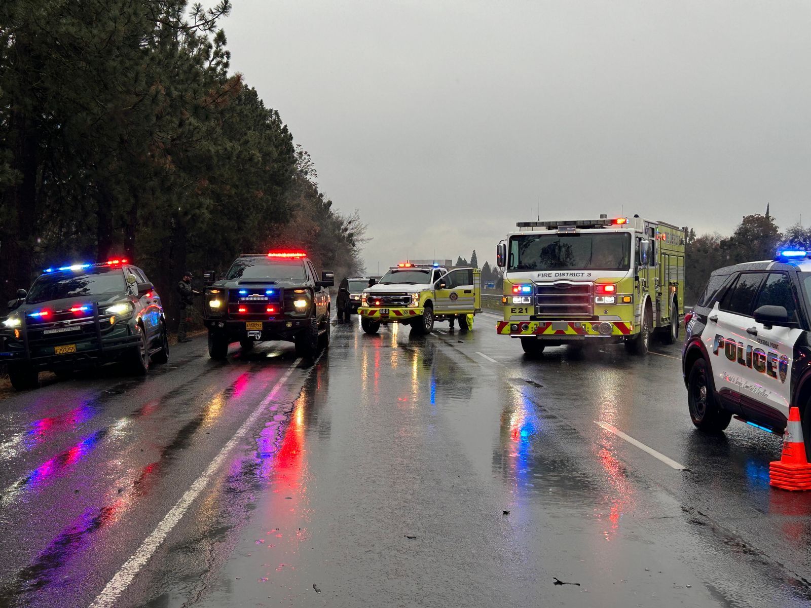 Police cars and fire trucks respond to a motorcycle accident on a rainy day on I-5 near Central Point Oregon on December 13th, 2024.