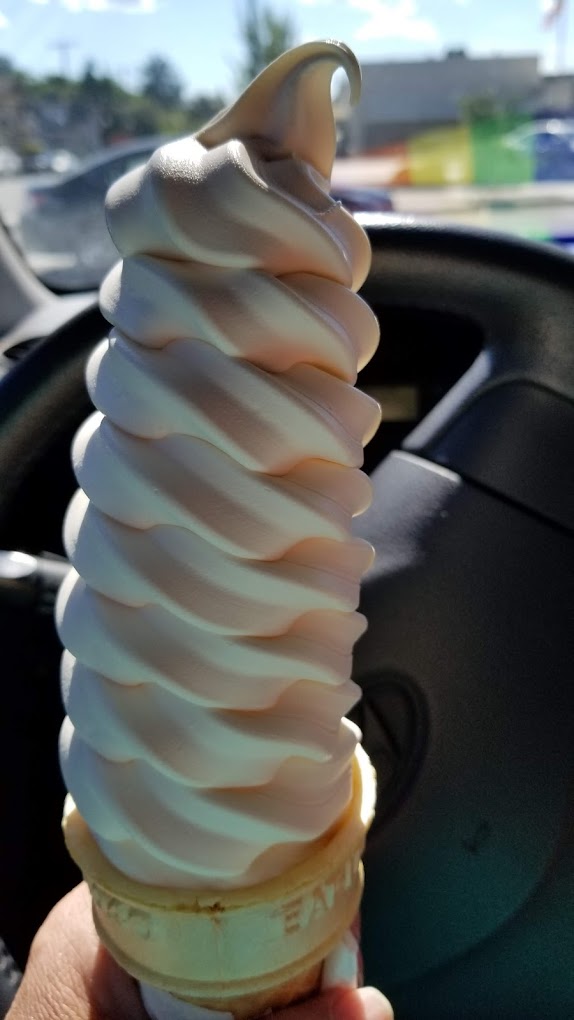 A towering white and pink ice cream cone.