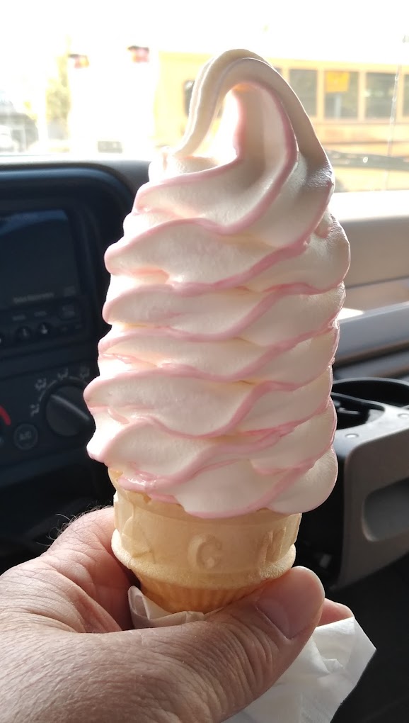 A tall white and pink ice cream cone.