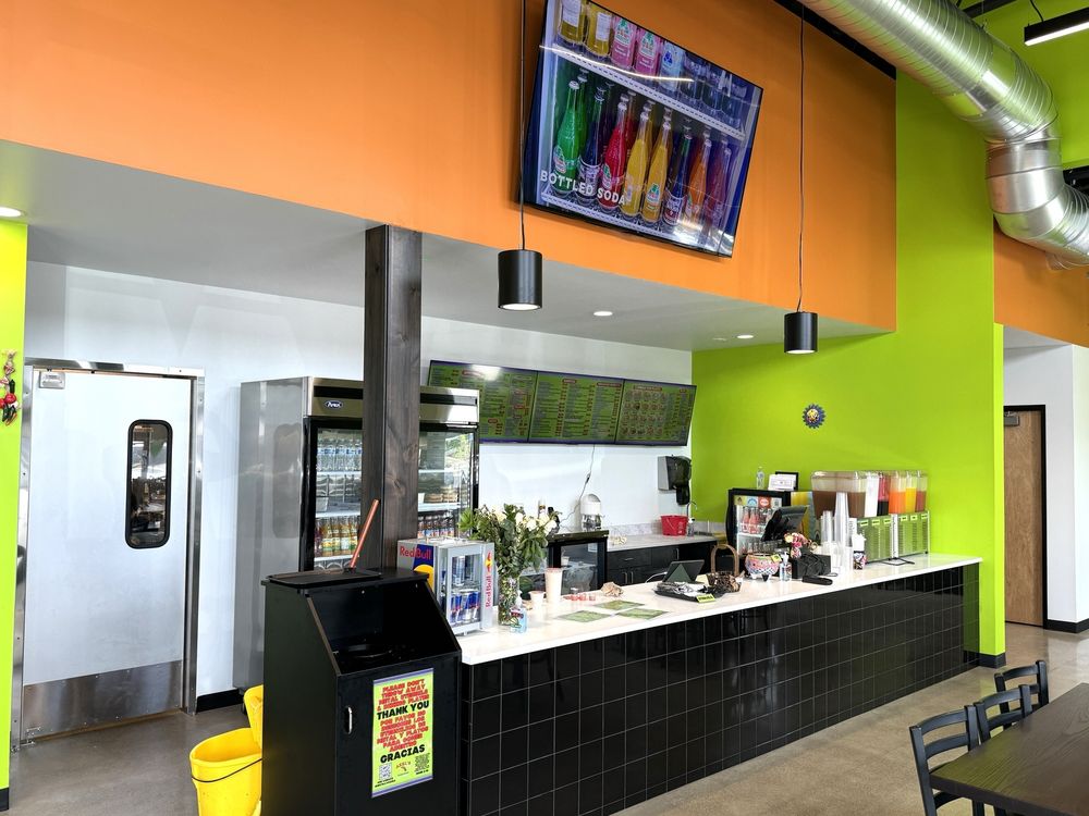 The service counter at Axel's Taco Shop in Bend, Oregon. The walls are green, and there's an orange accent wall.