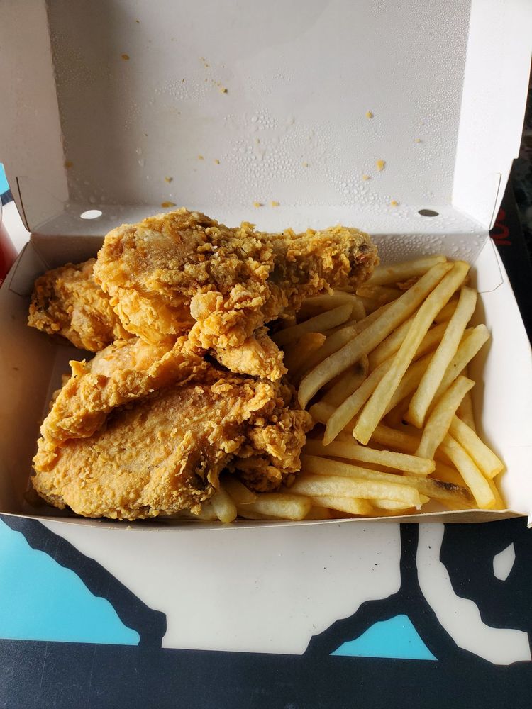 The 3 piece combo fried chicken with fries in a white to-go box.