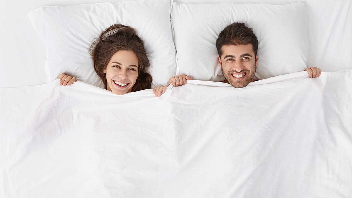 Happy couple laying in bed together