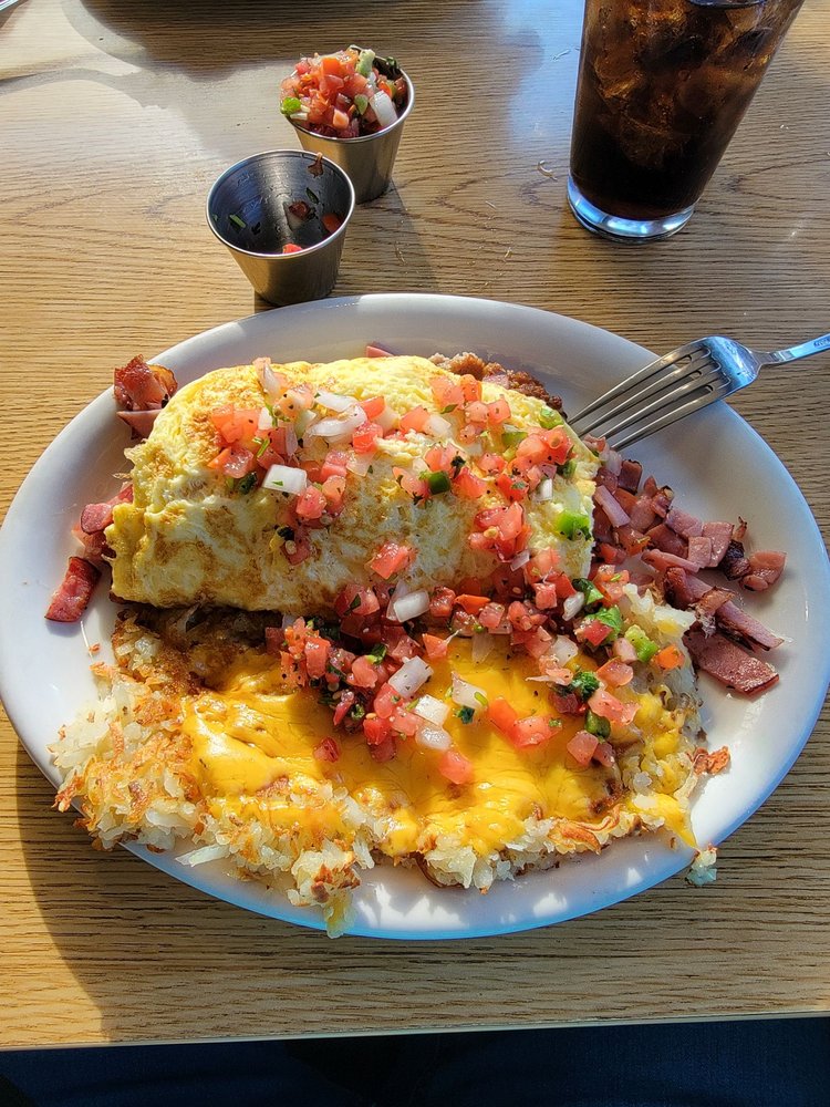 A killer looking omelet topped with tomatoes and onions. It looks so good!