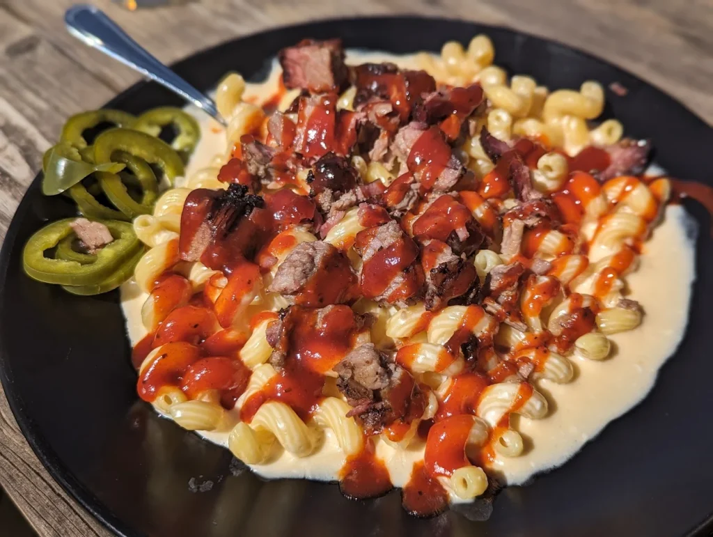 Mouthwatering brisket mac and cheese drizzled with a red sauce.