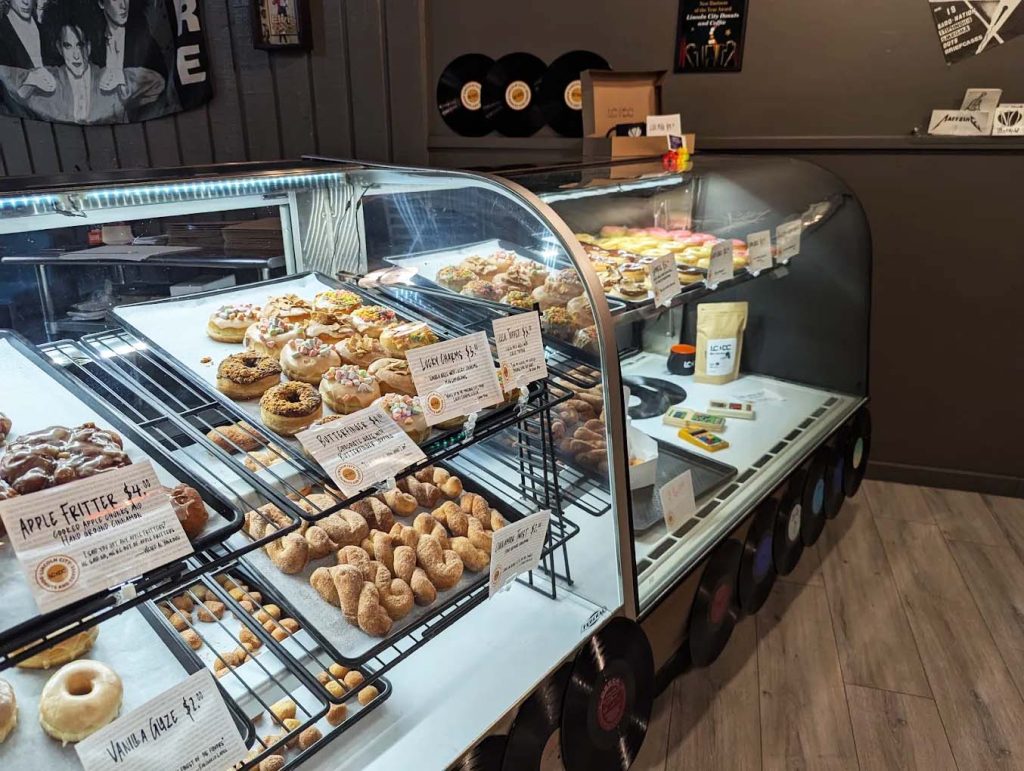 A glass display case full of delicious fresh baked donuts.