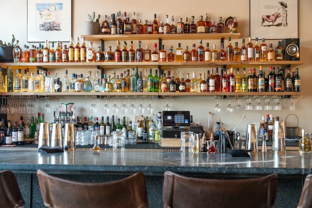 The bar at RBC. Alcohol lines the shelves in colorful glass bottles.