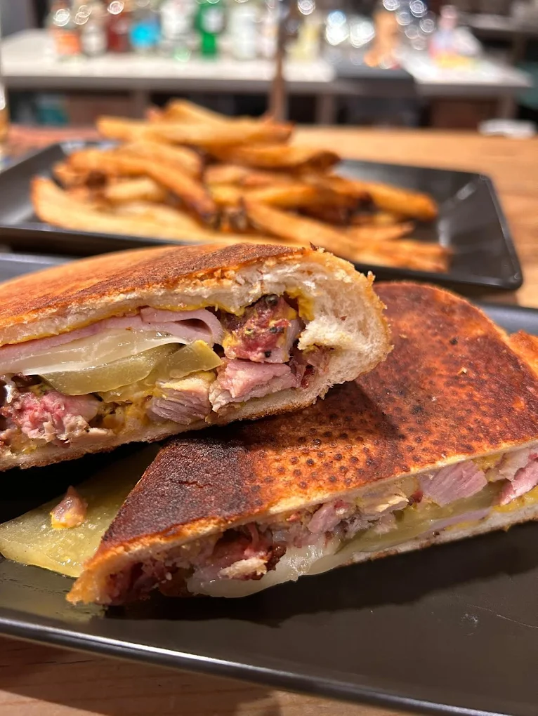 A meat sandwich with pickles and other toppings.