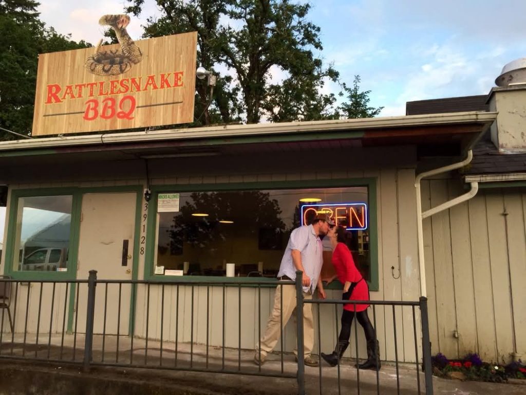 A couple kisses outside of the Rattlesnake BBQ at the Dexter Lake Club.