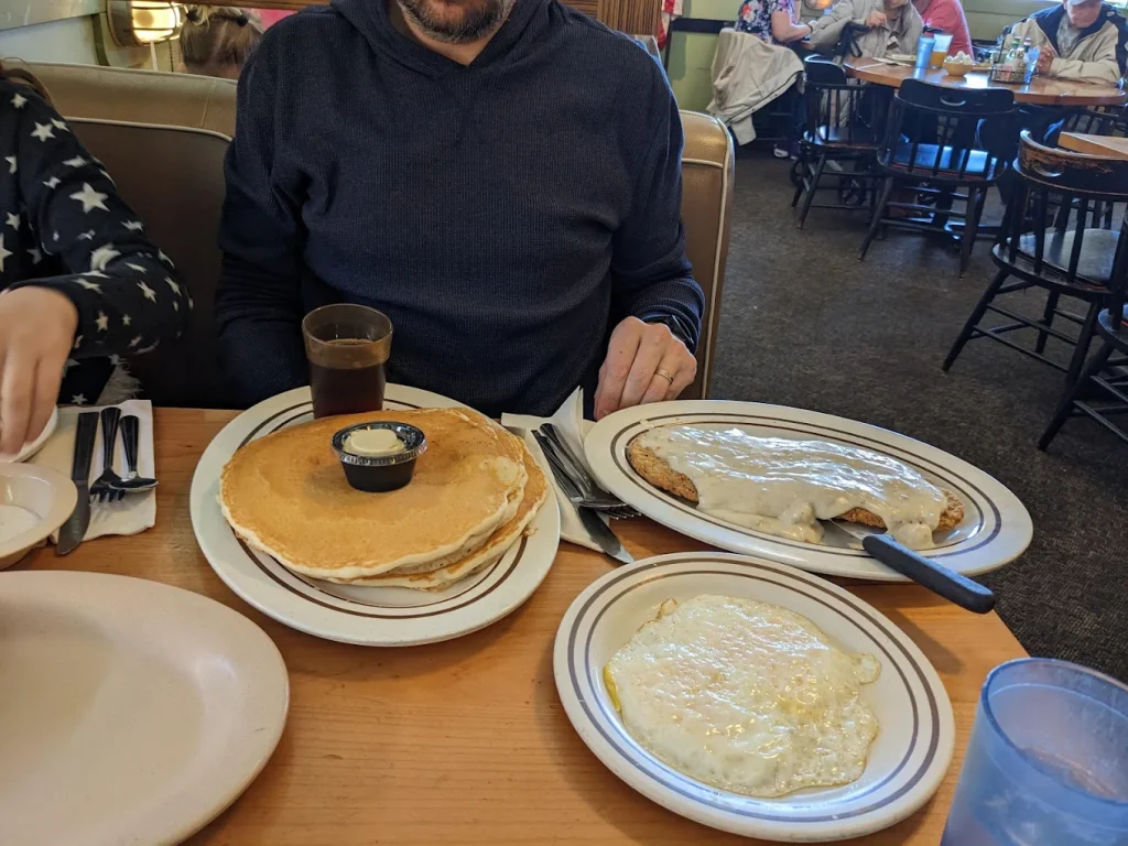 Pancakes, eggs, and chicken fried steak, all so big they have to sit on their own plate.