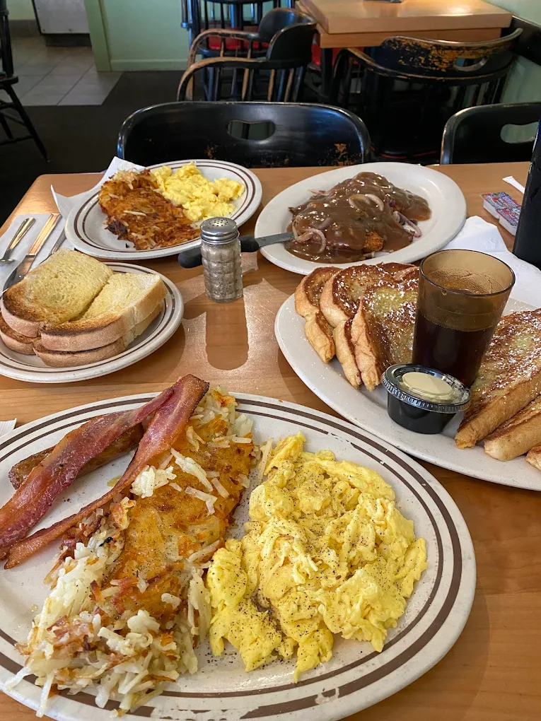 Huge plates full of various breakfast foods set on a table.
