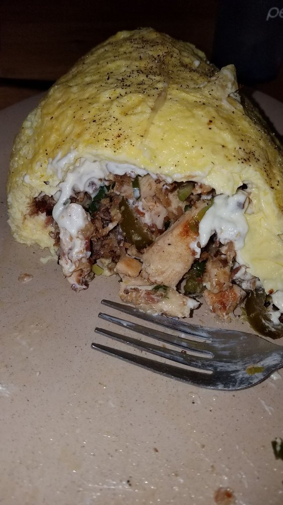 An omelet filled with meat and veggies.