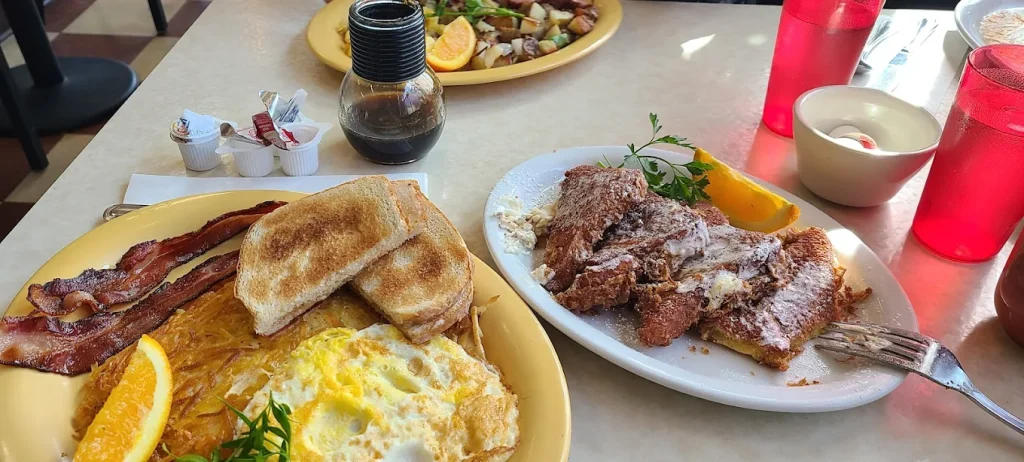 A table with several plates of delicious looking breakfast food.