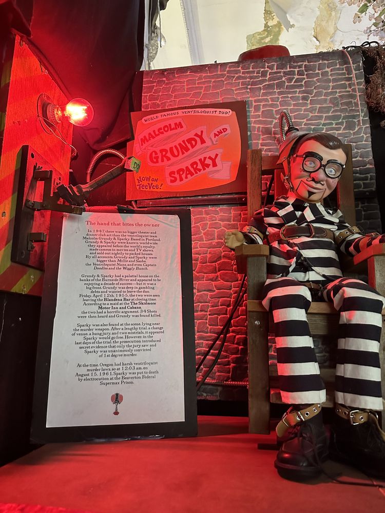 A creepy doll sits in an electric chair.