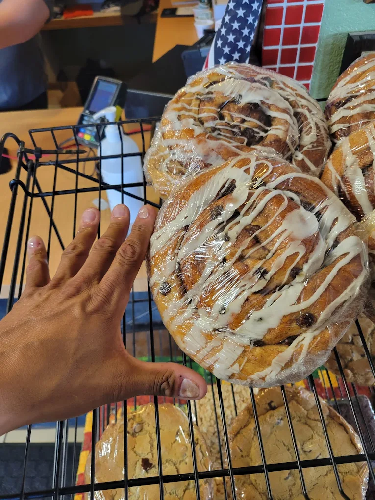 Cinnamon rolls bigger than a person's hand, wrapped in plastic because they're meant to be taken home.