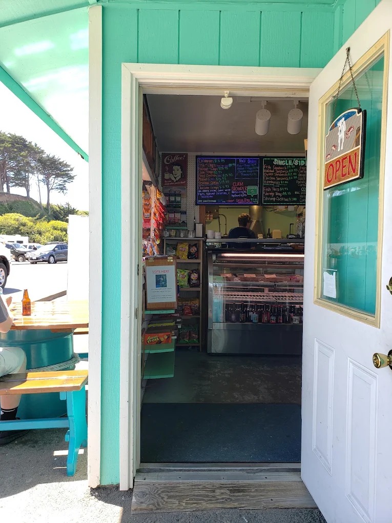 Interior of Bandon Bait in Bandon, Oregon, showing casual seafood counter service, fishing gear displays, and a cozy coastal bait shop atmosphere.