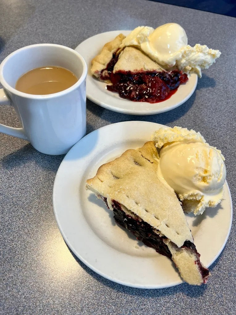 Slice of marionberry pie topped with vanilla ice cream and whipped cream at The Berry Patch Restaurant Westport Oregon