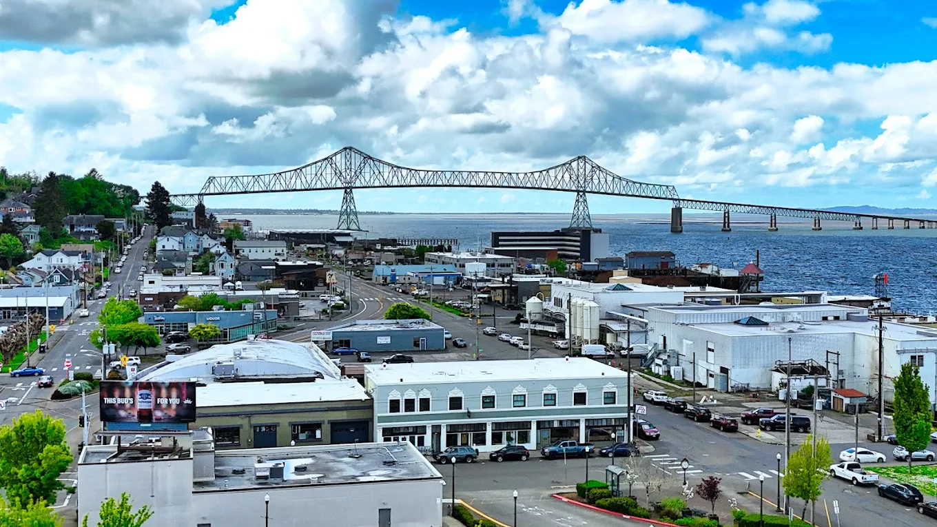Astoria, Oregon. Photo by Steve Smith via Google Local/ Businesses in Astoria with the iconic Astoria-Megler Bridge behind them, stretching over the river.