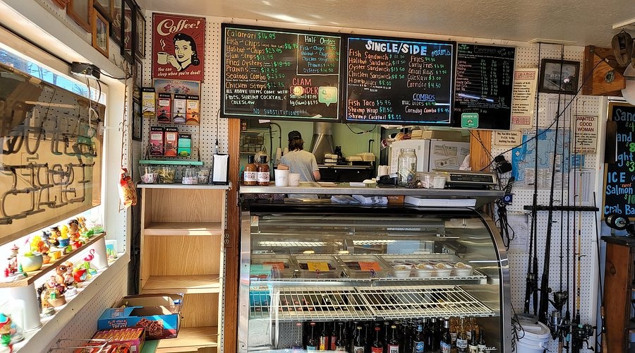 Interior of Bandon Bait in Bandon, Oregon, showing casual seafood counter service, fishing gear displays, and a cozy coastal bait shop atmosphere.
