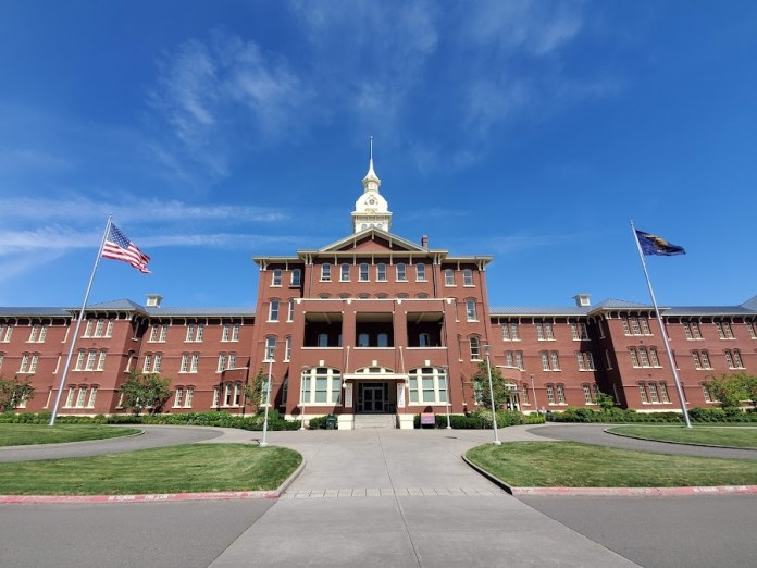Oregon State Hospital Kirkbride building exterior in Salem Oregon modern view of historic insane asylum architecture with flags and entrance