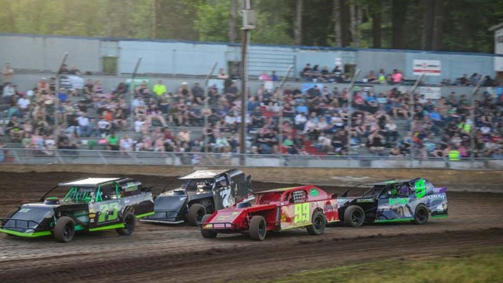 Race cars kicking up dirt during an event at Cottage Grove Speedway.