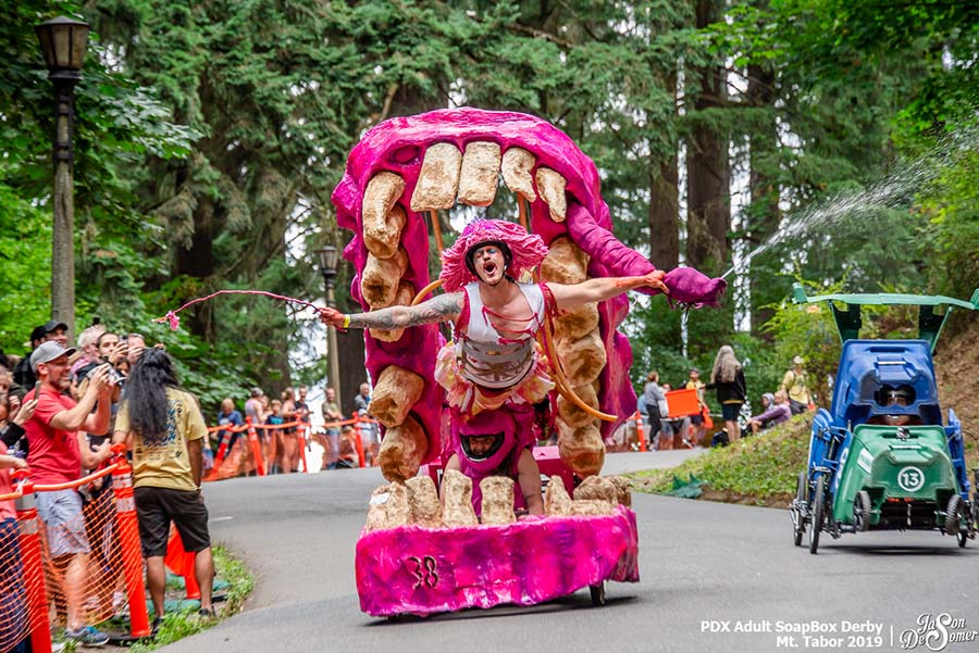 Creative gravity-powered race car and team participating in the Portland Adult Soapbox Derby at Mt. Tabor Park.
