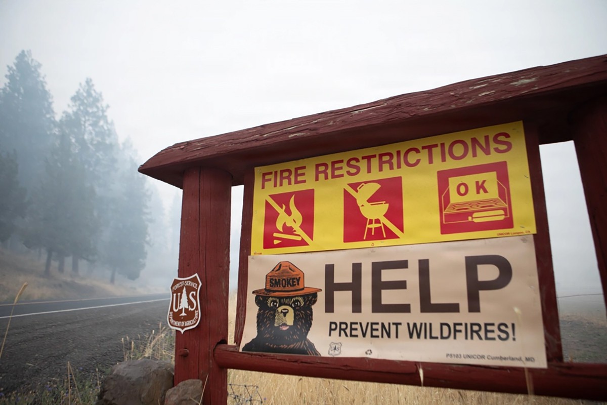 fire_restrictions Fire-restrictions and Smokey Bear signs beside a smoke-filled road near Prineville during the Rowe Creek Complex.