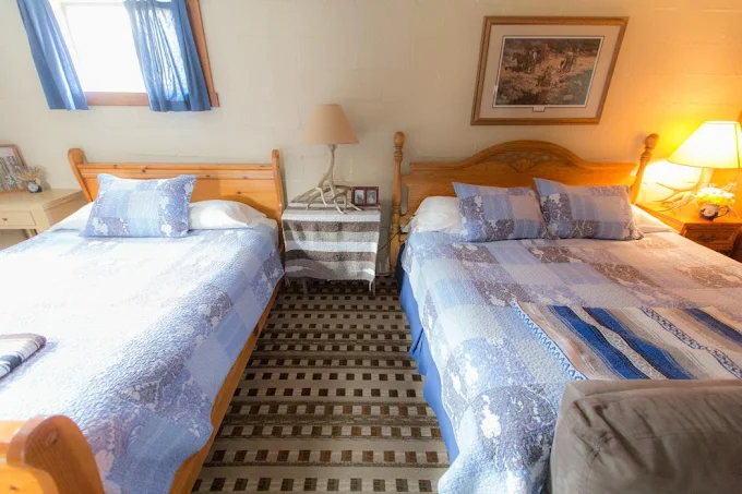 A comfortable guest room with two beds and quilts at Wilson Ranches Retreat