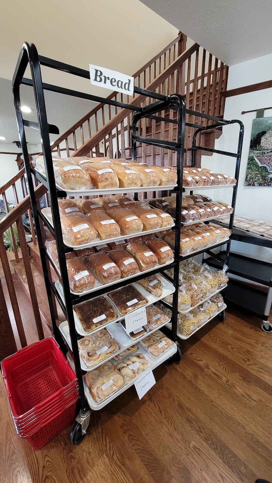 Wrapped bread loaves and pastries on rolling racks at Country Bakery.