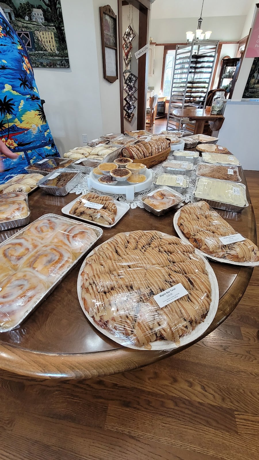 Iced cinnamon rolls and a large glazed pastry share the bakery’s display table.