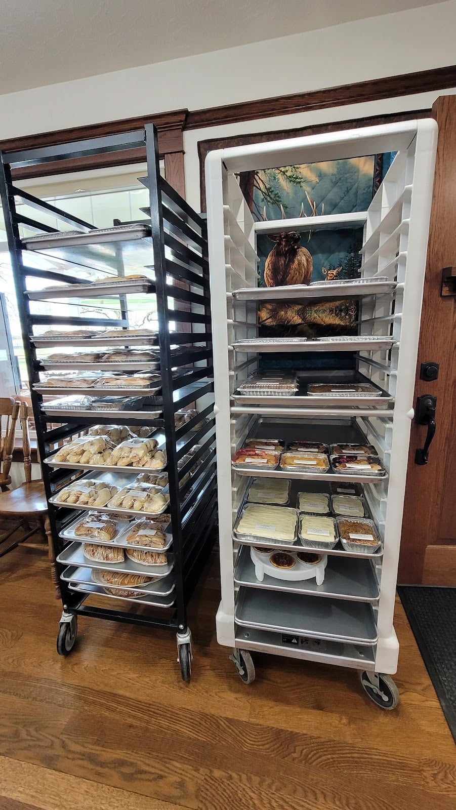 Trays of packaged pastries and cakes on racks inside Country Bakery.