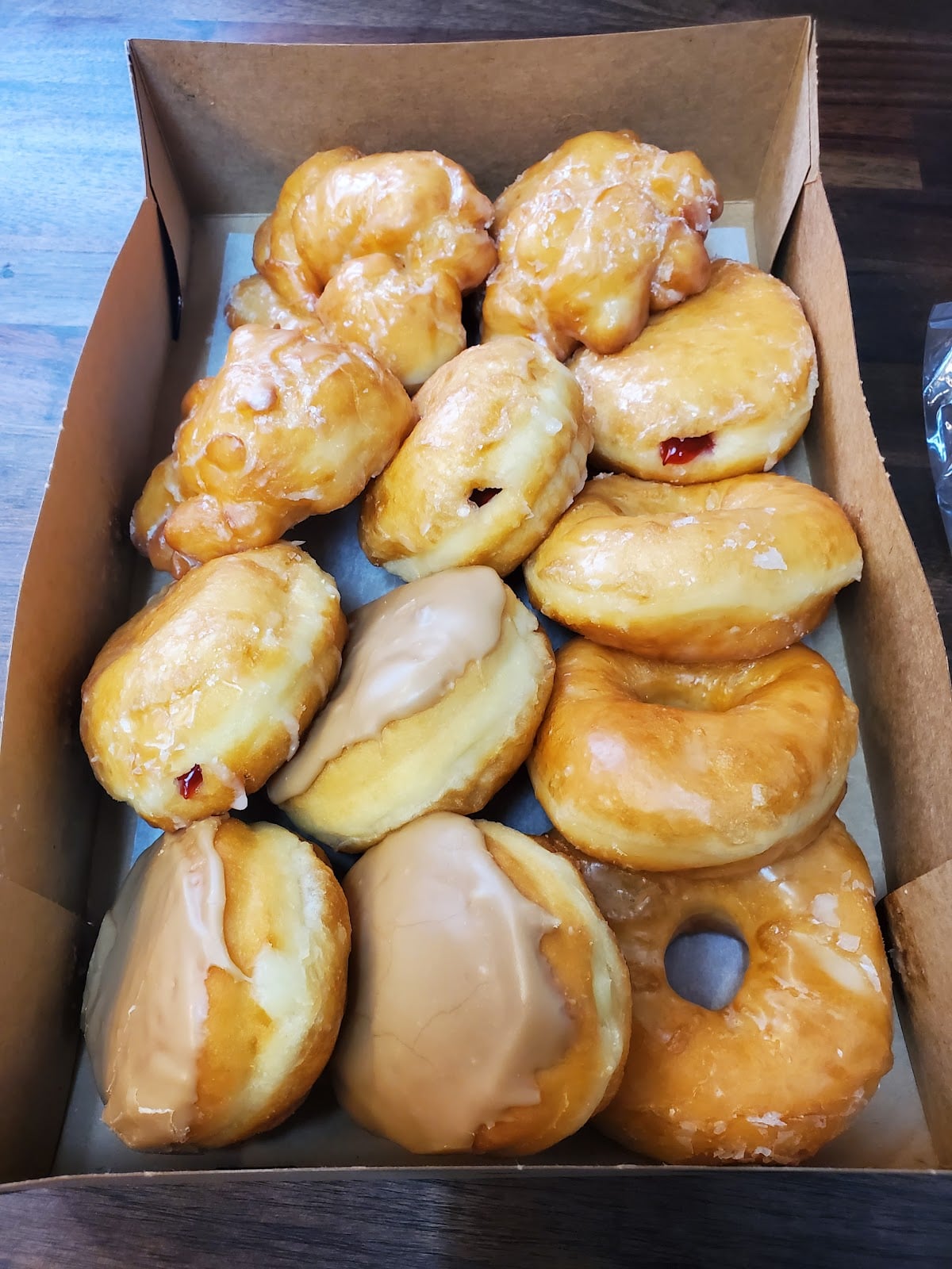 A box of glazed, iced, and filled doughnuts from Country Bakery.