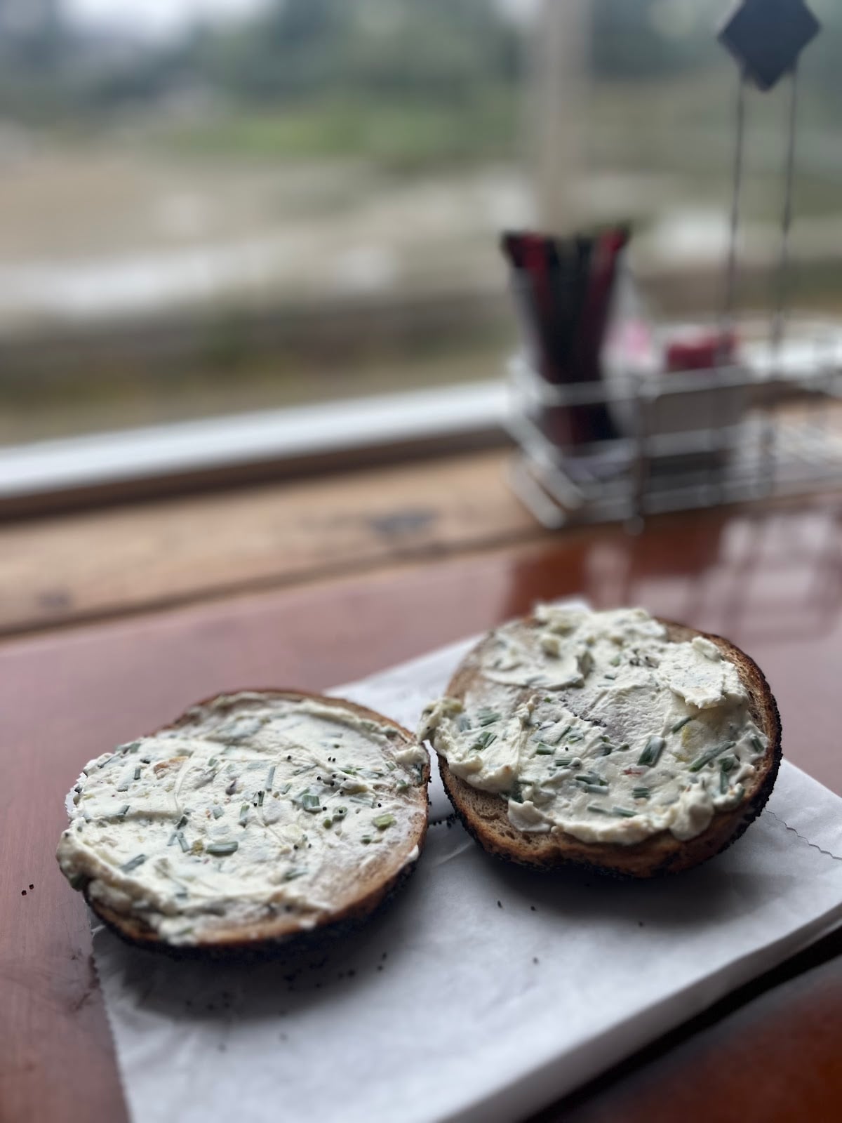 Cream cheese-covered bagel halves beside a window at Grumblefish.