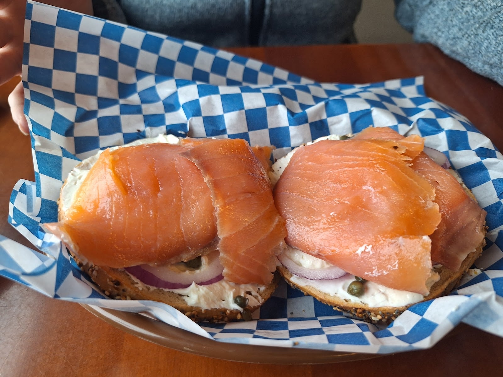Salmon, cream cheese, red onion, and capers on open bagel halves.