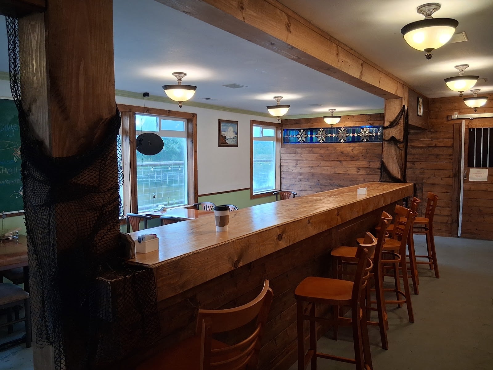Wooden counter seating and windows inside Grumblefish Bagels.