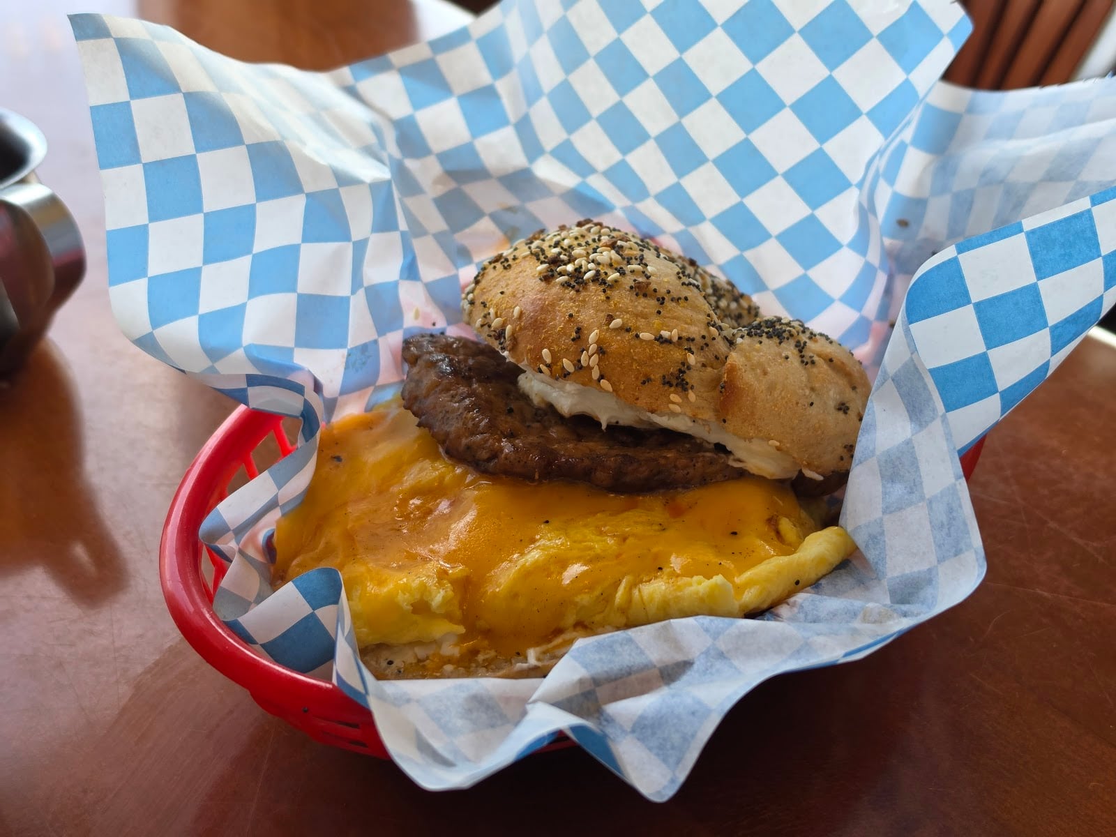 An everything bagel breakfast sandwich with a sausage patty, egg, and cheese.