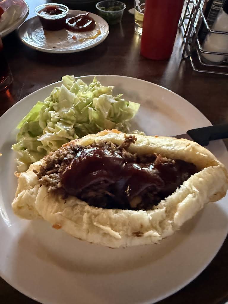 Barbecue sandwich with sauce and a side salad at Mac’s Place in Silverton
