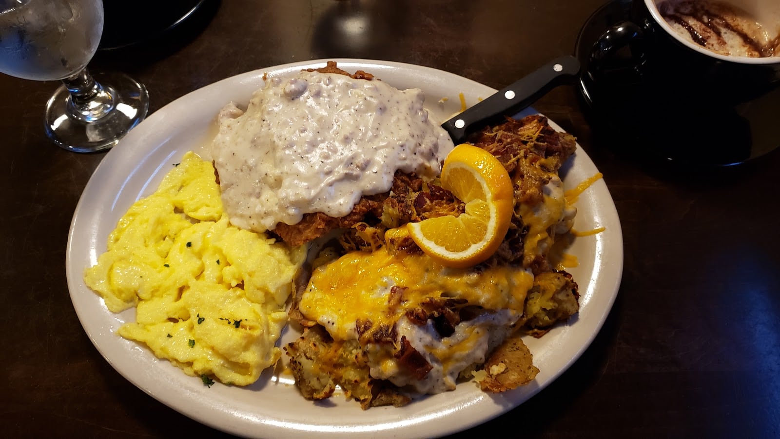 Chicken-fried steak with gravy, scrambled eggs, and loaded potatoes.