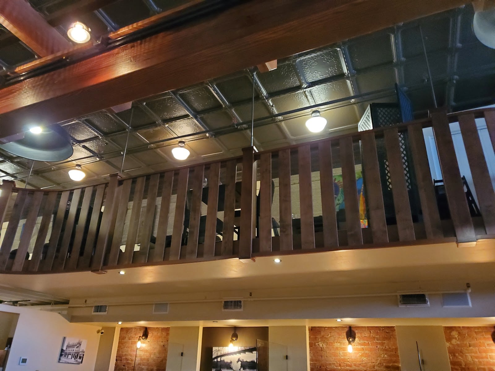 A view of the cafe’s high ceiling, upper railing, and exposed brick.