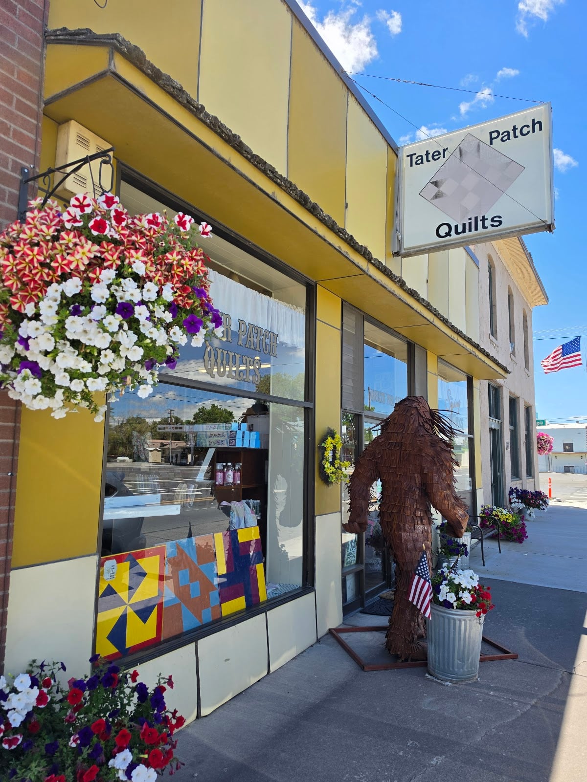 Hanging flowers, quilt blocks, and a Sasquatch welcome visitors on Front Street.