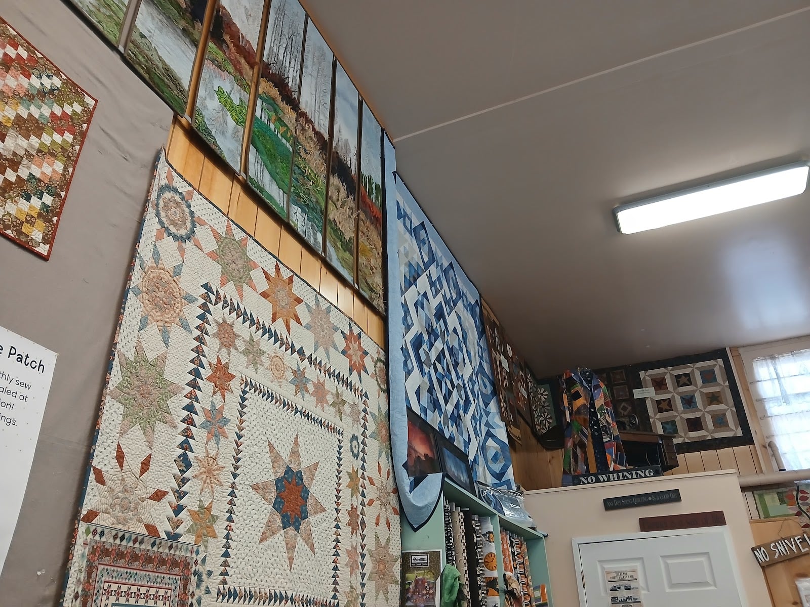 Large quilts make use of the high wall space inside the Merrill store.