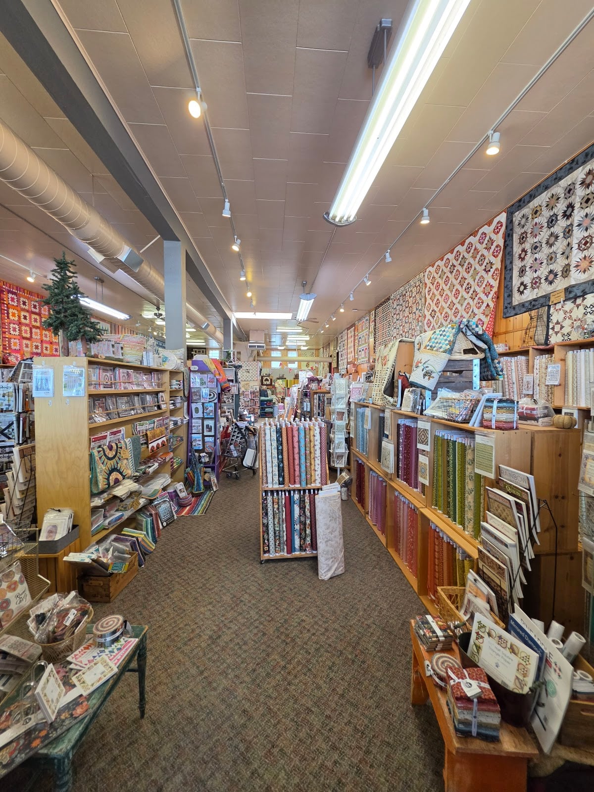 A long aisle leads through the shop’s fabric and project displays.