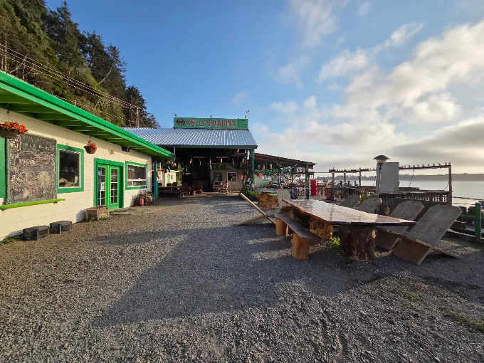 Green-trimmed marina buildings and wooden picnic tables beside Nehalem Bay