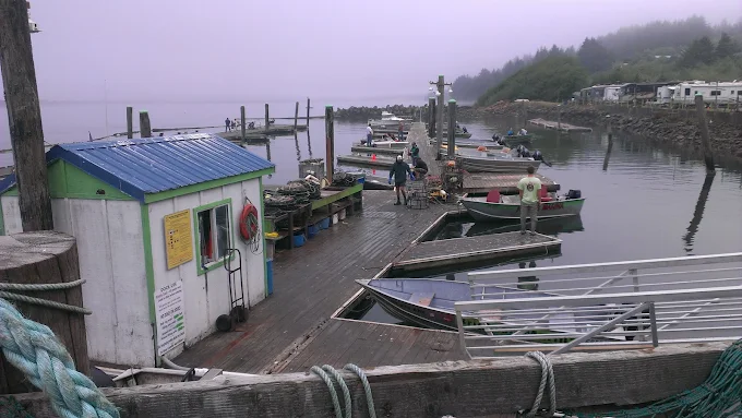 Rental boats and docks in coastal fog with RV campsites along the waterfront