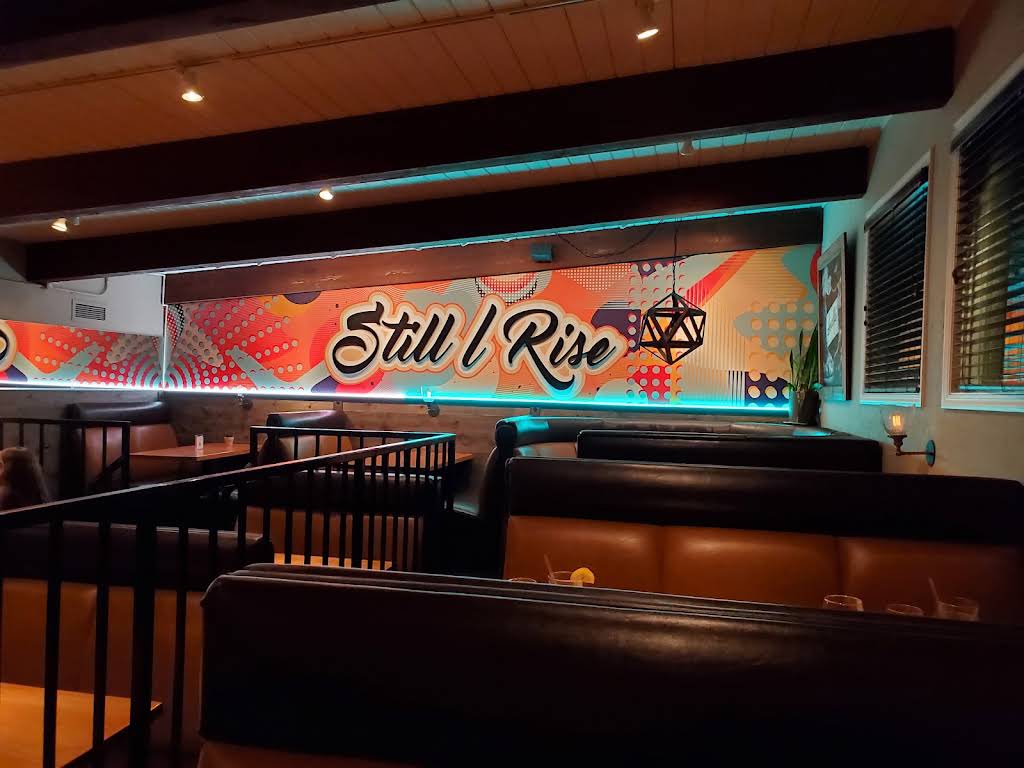 Brown leather booths beneath the colorful Still I Rise mural at Amalfi’s Italian Restaurant in Portland