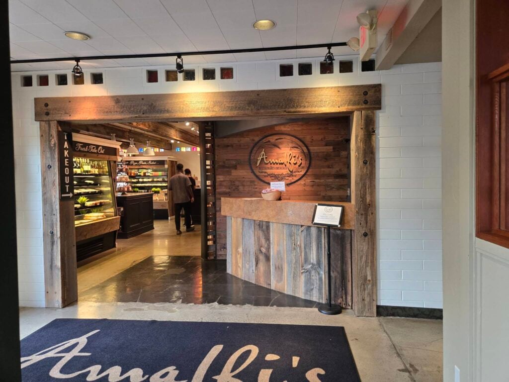 Wood-trimmed entrance and reception desk beside the Mercato at Amalfi’s in Northeast Portland