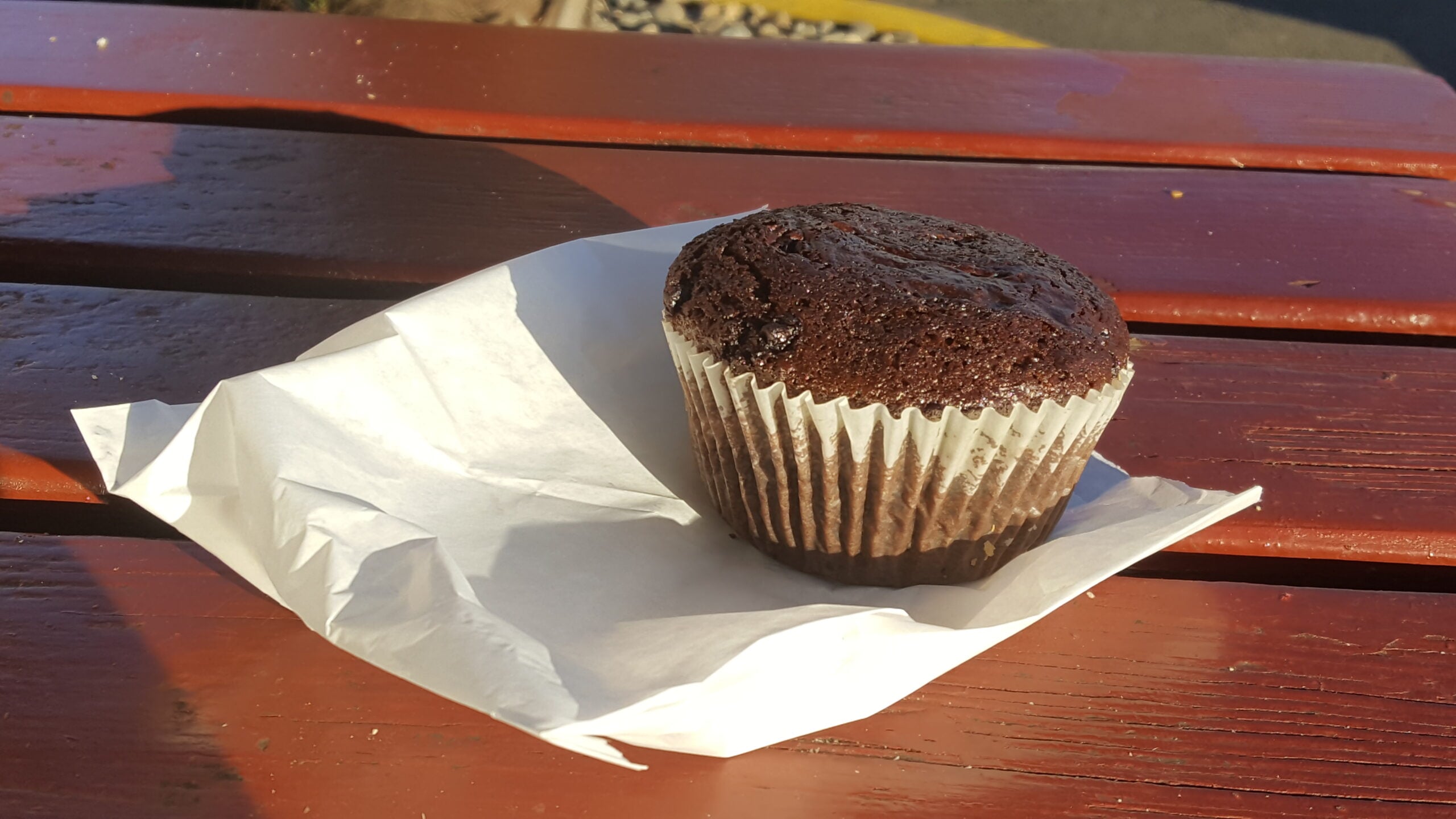 A small baked treat in a paper liner on an outdoor table, An Xuyên Bakery, Portland oregon, foster road, vietnamese food, chinese goodies, french baguette, baked fresh daily, bao, bánh mì, cheesecake, cafe, quick snacks, croissants