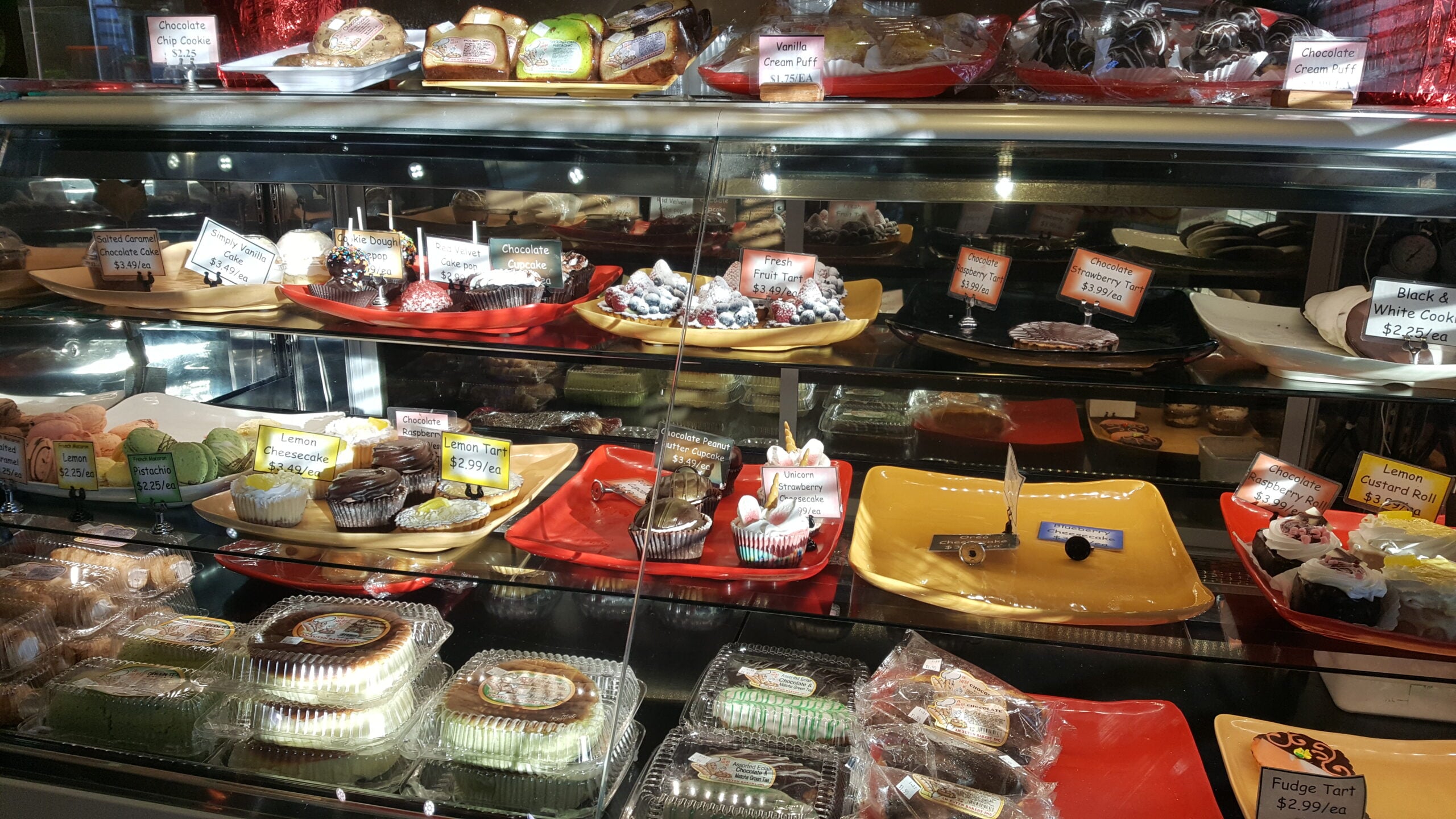 Individual cakes and other desserts displayed in a glass bakery case, An Xuyên Bakery, Portland oregon, foster road, vietnamese food, chinese goodies, french baguette, baked fresh daily, bao, bánh mì, cheesecake, cafe, quick snacks, croissants