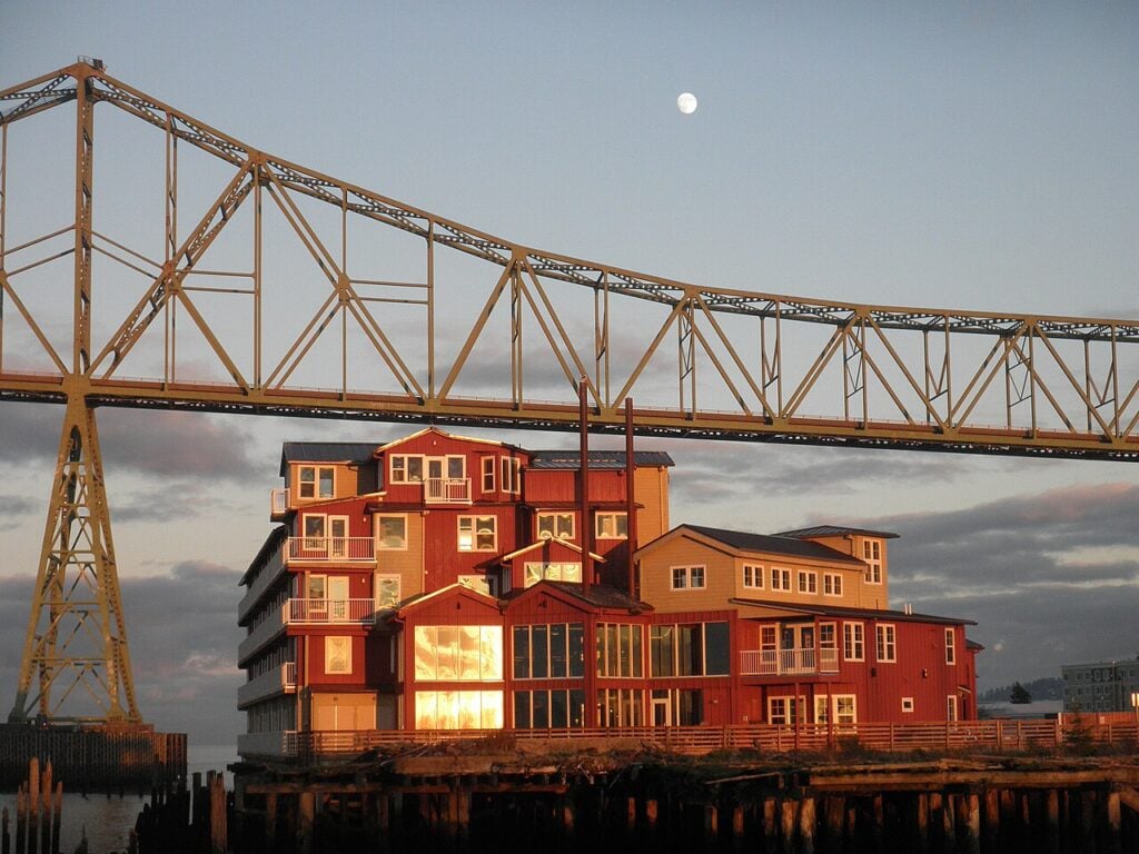 Cannery Pier Hotel illuminated beneath the Astoria Megler Bridge beside the Columbia River